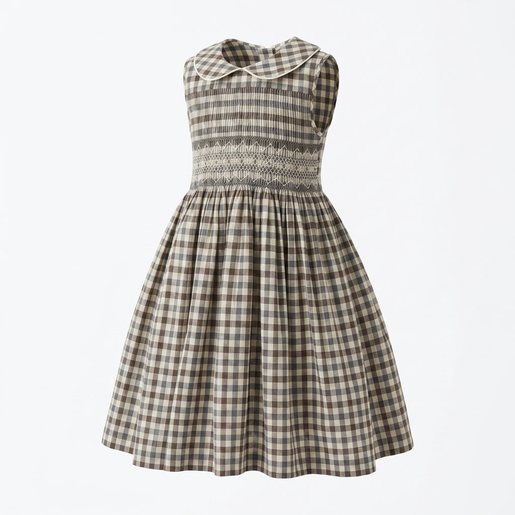 A hand smocked girl's dress with a grey gingham pattern, featuring a Peter Pan collar, smocked bodice, and flared skirt.