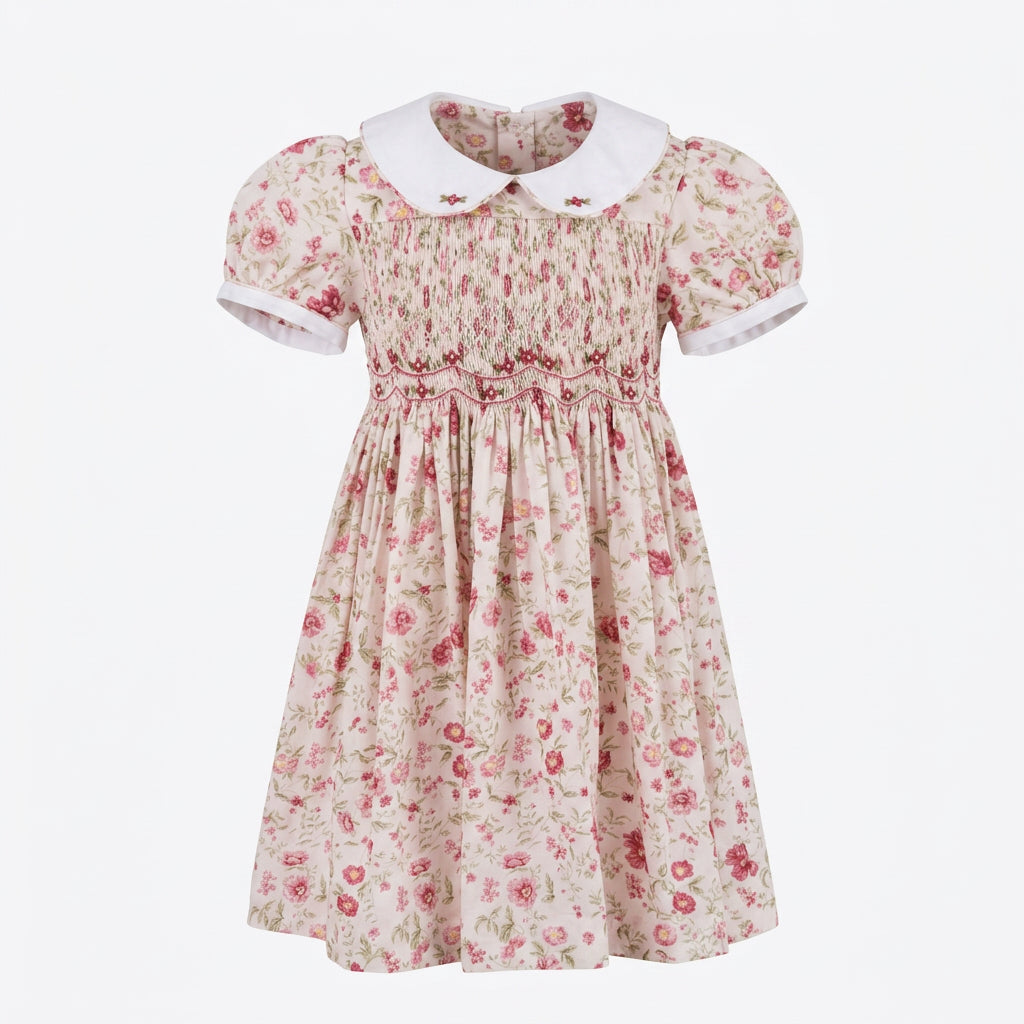 A vintage-style girl's hand smocked dress with short puff sleeves, and a white Peter Pan collar. 